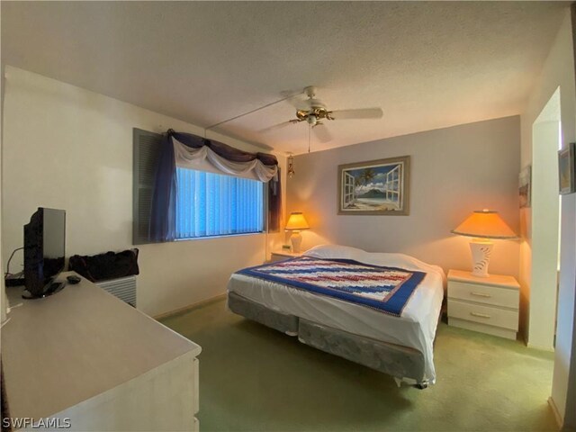 carpeted bedroom featuring a textured ceiling and ceiling fan