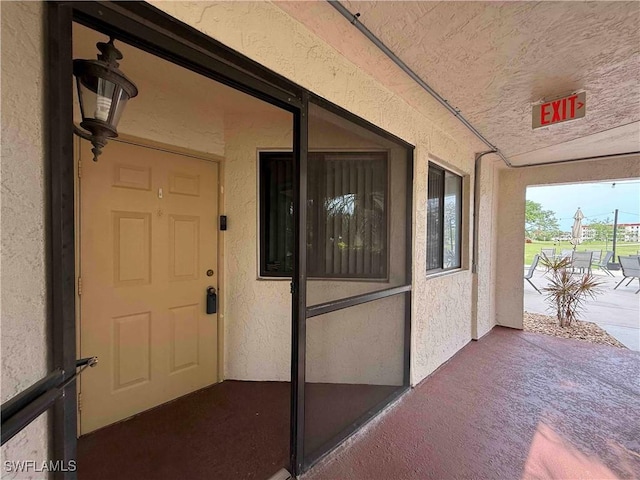 doorway to property featuring stucco siding