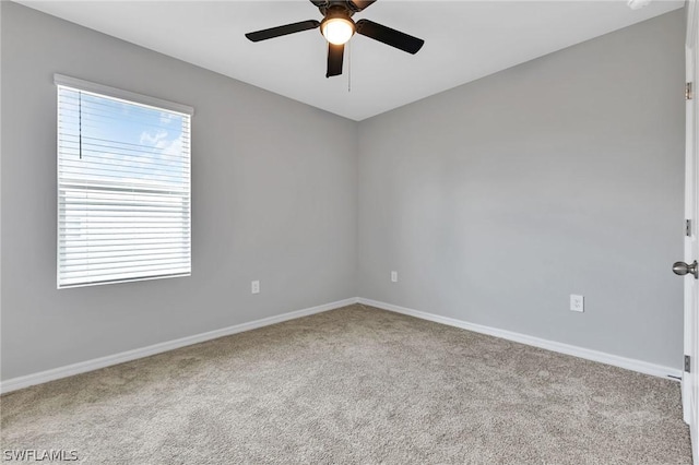 carpeted spare room featuring ceiling fan