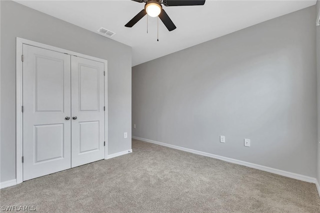 unfurnished bedroom featuring a closet, ceiling fan, and light colored carpet