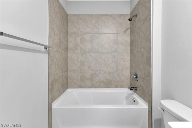 bathroom with toilet and tiled shower / bath