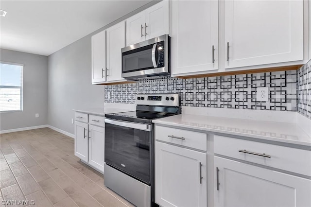 kitchen with decorative backsplash, white cabinetry, and appliances with stainless steel finishes