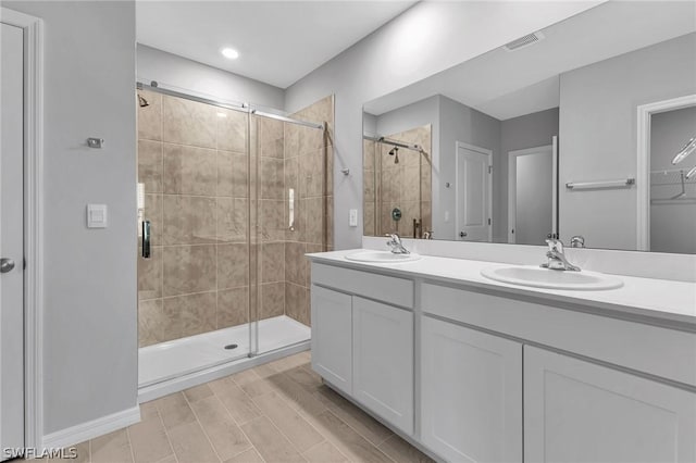 bathroom featuring vanity and a shower with door