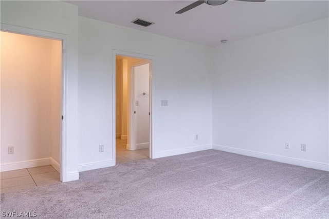 carpeted spare room featuring ceiling fan