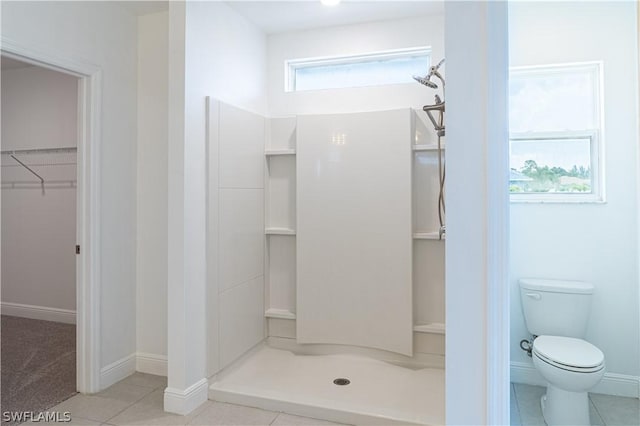 bathroom featuring tile patterned flooring, toilet, and walk in shower