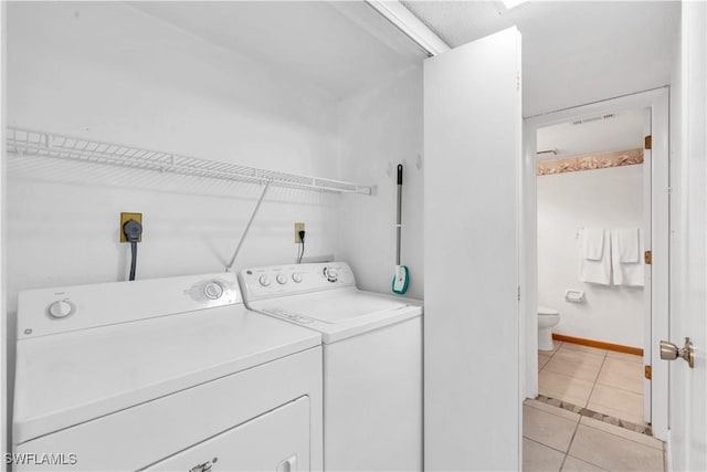 laundry room with washer and dryer and light tile patterned floors