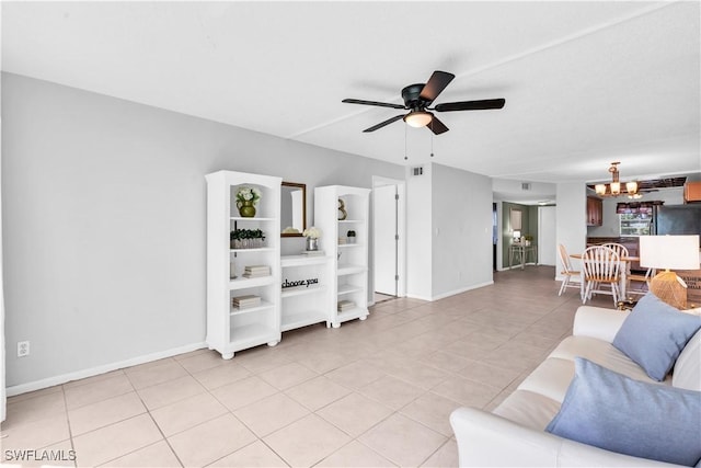 tiled living room featuring ceiling fan with notable chandelier