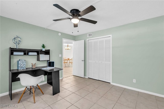 tiled office space featuring ceiling fan with notable chandelier