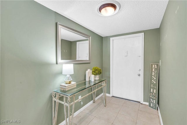 entryway featuring light tile patterned floors and a textured ceiling