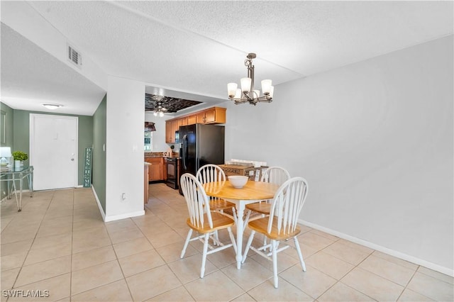 dining space featuring ceiling fan with notable chandelier, light tile patterned flooring, and a textured ceiling