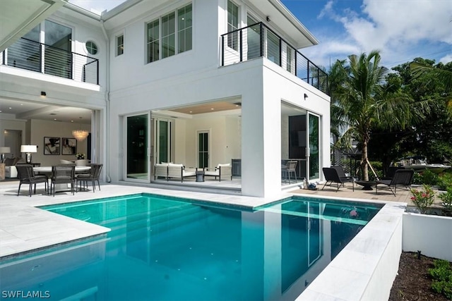 rear view of property with a patio area, a balcony, and an outdoor hangout area