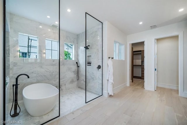 bathroom featuring hardwood / wood-style floors and shower with separate bathtub