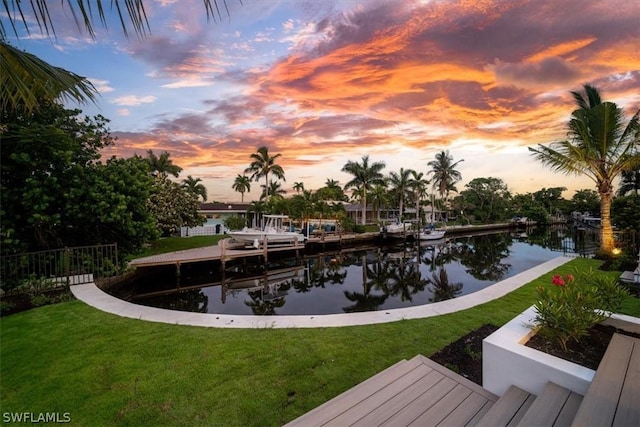 exterior space with a lawn, a water view, and a dock