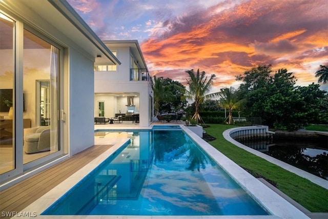 pool at dusk with a lawn