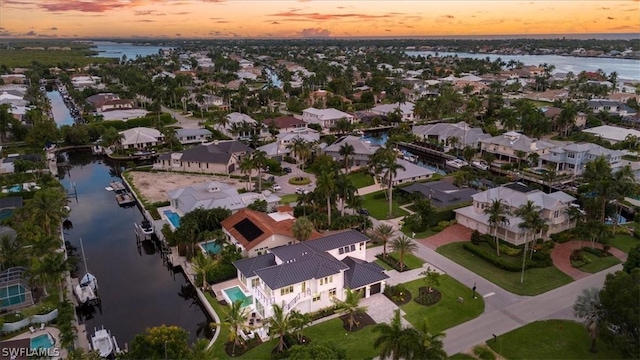 aerial view at dusk featuring a water view