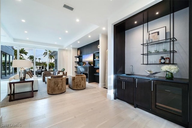 living room with light hardwood / wood-style flooring and indoor wet bar