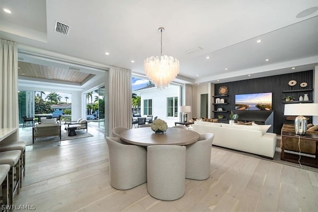 dining space with light hardwood / wood-style flooring and an inviting chandelier