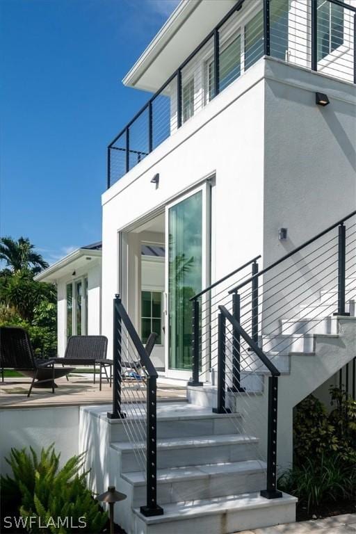 entrance to property featuring a patio area and a balcony