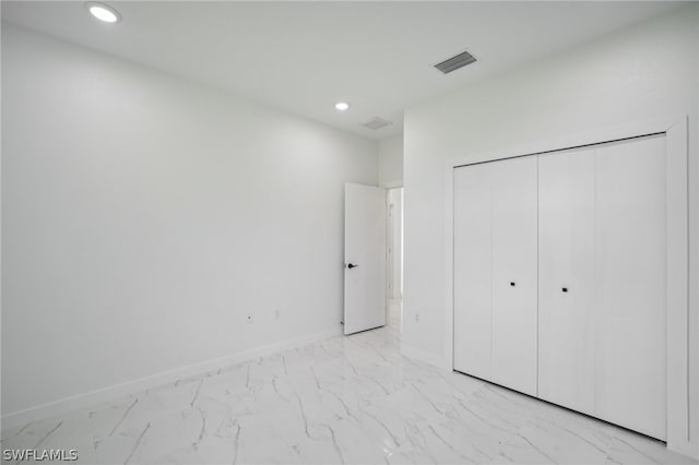 unfurnished bedroom with light tile patterned flooring and a closet