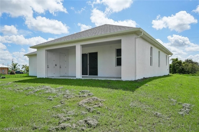 rear view of house featuring a yard