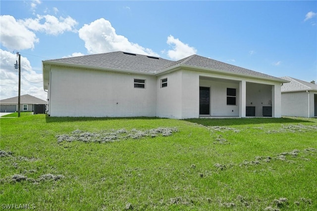 back of house with a yard and central AC