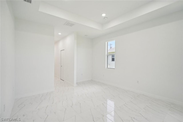 unfurnished room featuring a tray ceiling