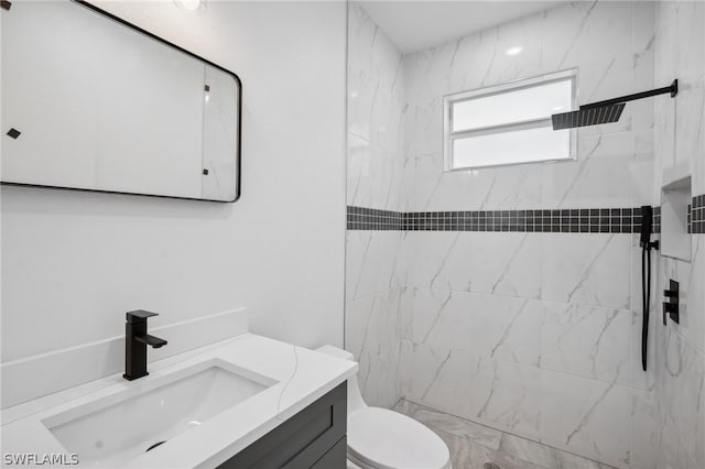 bathroom with toilet, vanity, and a tile shower