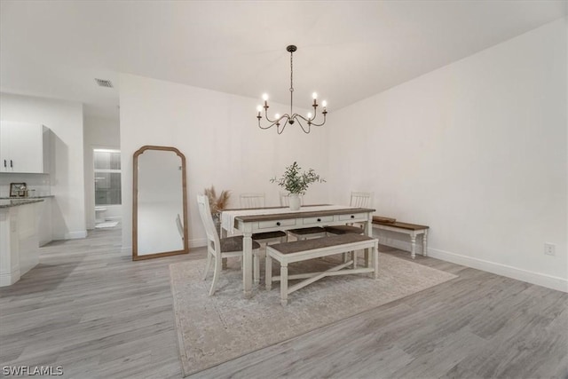 dining room with a chandelier and light hardwood / wood-style floors