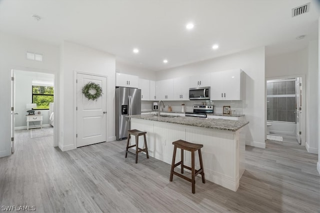 kitchen featuring light hardwood / wood-style floors, sink, stainless steel appliances, and white cabinetry