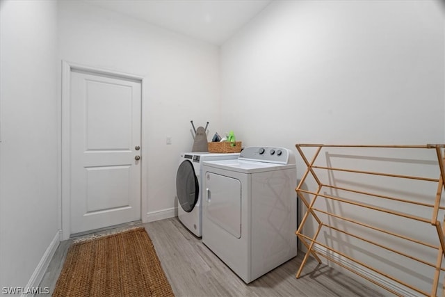 washroom featuring independent washer and dryer and light hardwood / wood-style flooring