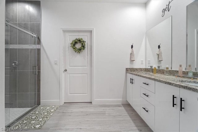 bathroom with wood-type flooring, an enclosed shower, and vanity