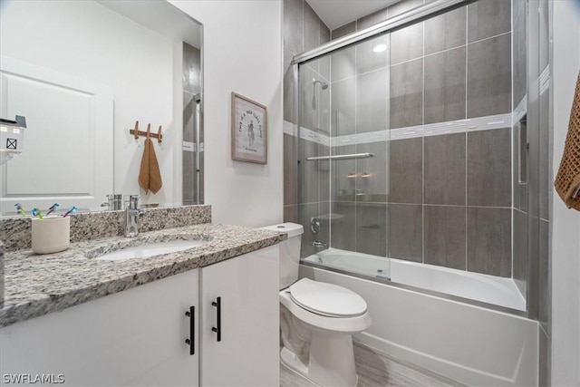 full bathroom featuring combined bath / shower with glass door, vanity, and toilet