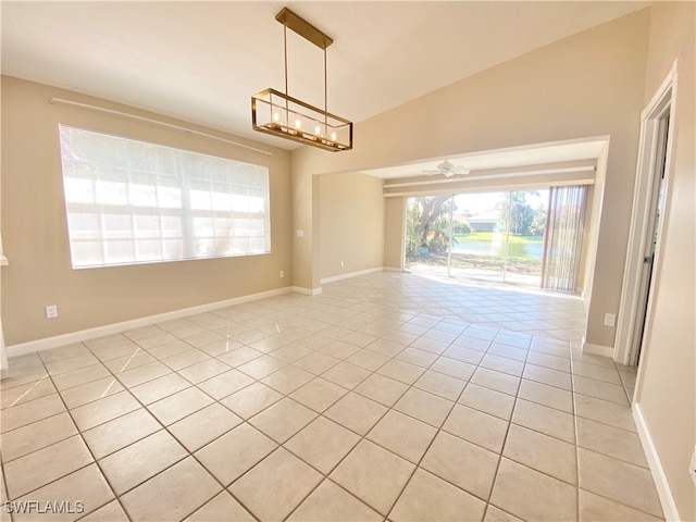 unfurnished room with light tile patterned floors, lofted ceiling, and ceiling fan with notable chandelier