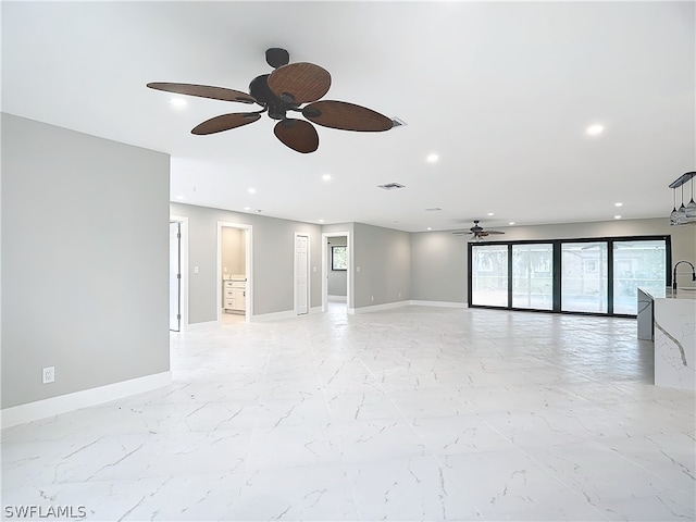 tiled empty room featuring sink and ceiling fan