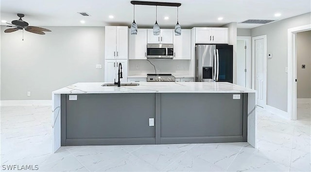 kitchen featuring white cabinetry, an island with sink, sink, light stone counters, and stainless steel appliances