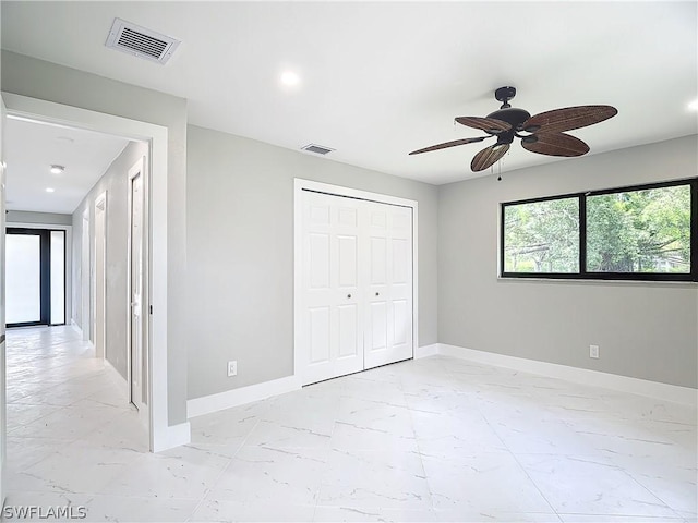 unfurnished bedroom featuring ceiling fan and a closet