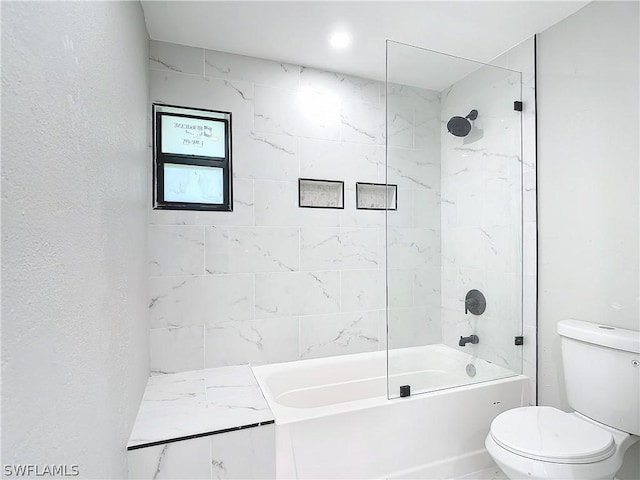 bathroom featuring toilet and tiled shower / bath combo