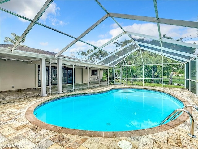 view of swimming pool featuring a lanai and a patio area