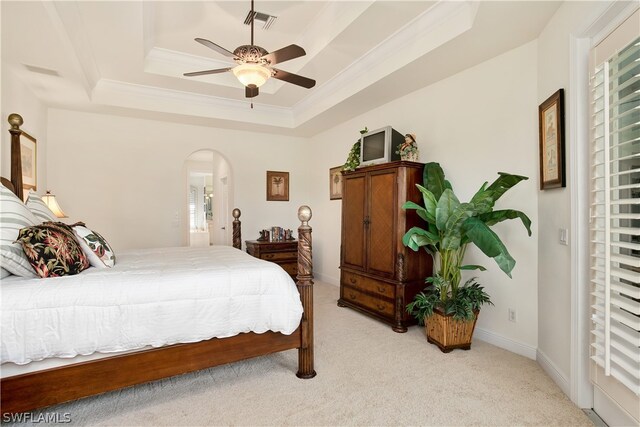 bedroom featuring ceiling fan, light colored carpet, ornamental molding, and a raised ceiling