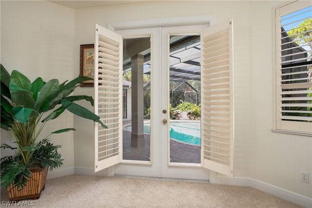 doorway to outside with light carpet and french doors