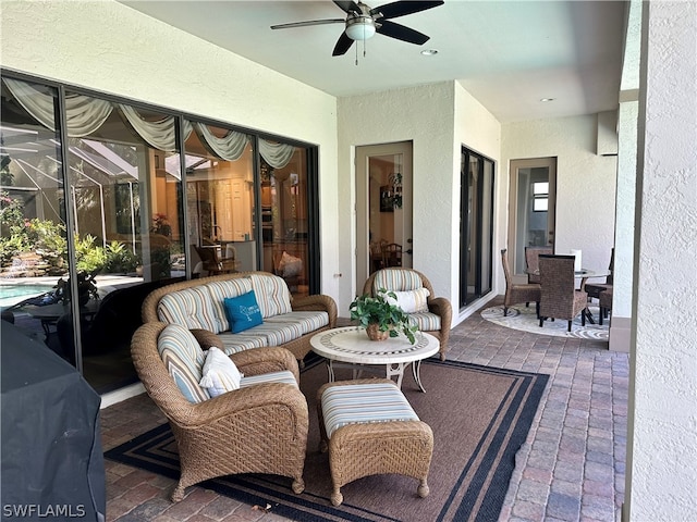 view of patio / terrace featuring ceiling fan, an outdoor hangout area, and glass enclosure