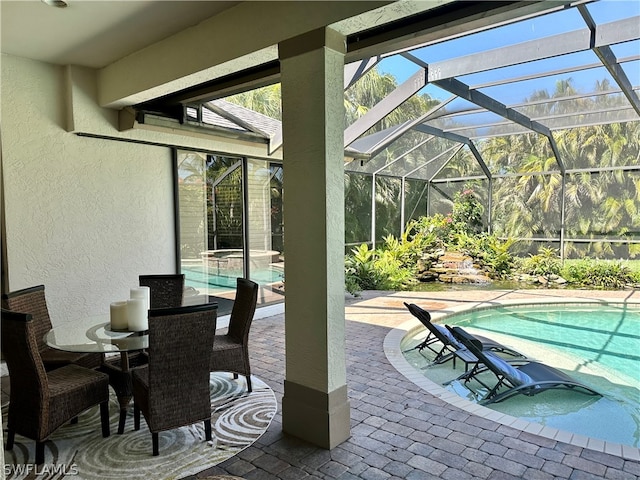 view of patio with glass enclosure and a swimming pool with hot tub