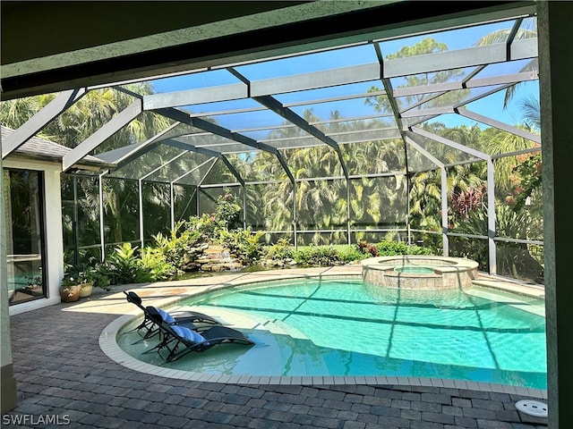 view of swimming pool featuring a lanai, a patio area, and an in ground hot tub