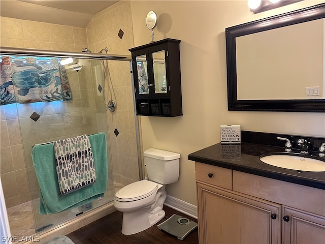 bathroom with walk in shower, vanity, wood-type flooring, and toilet