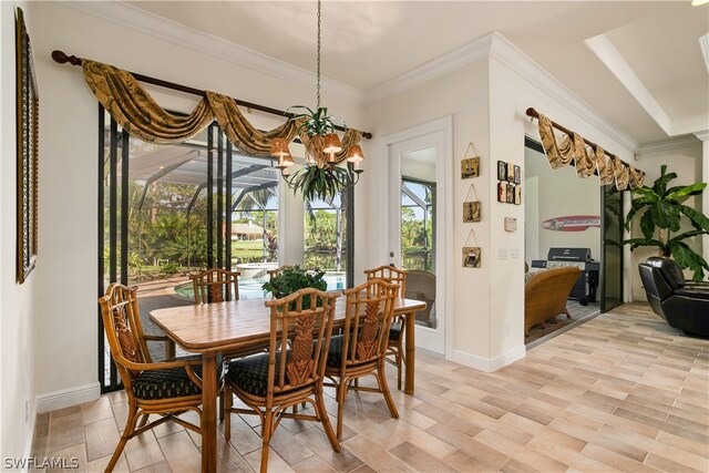 dining area with an inviting chandelier, ornamental molding, and light hardwood / wood-style flooring