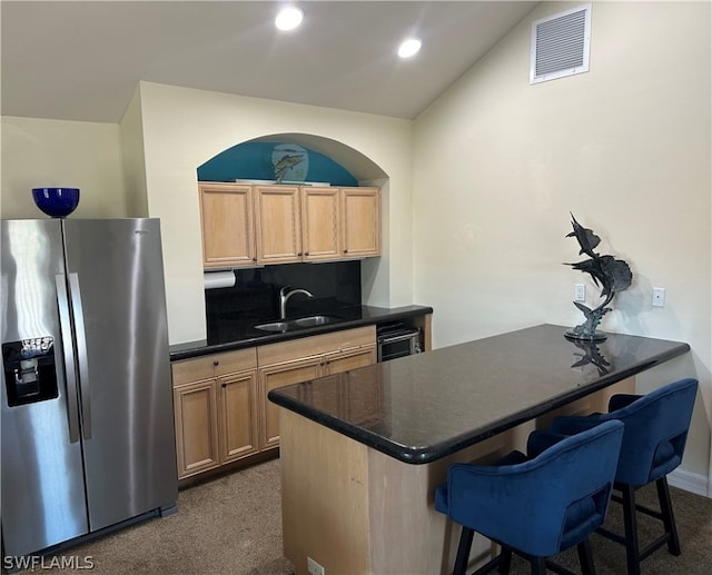 kitchen featuring stainless steel fridge with ice dispenser, a kitchen bar, kitchen peninsula, wine cooler, and sink