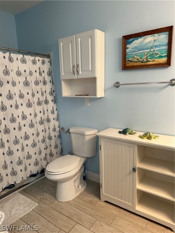 bathroom featuring toilet and a shower with curtain