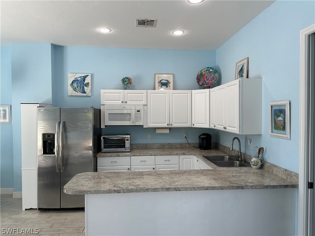 kitchen with sink, white cabinetry, stainless steel fridge with ice dispenser, and kitchen peninsula