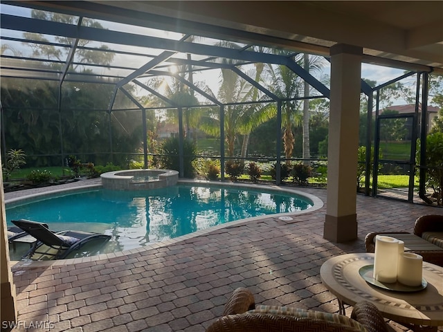 view of pool with a patio, glass enclosure, and an in ground hot tub