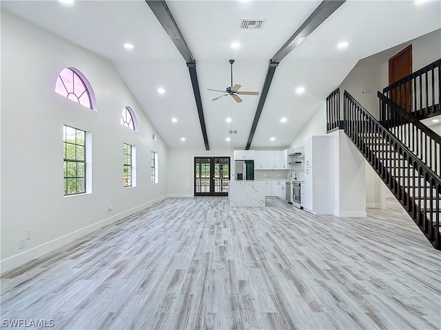 unfurnished living room with beamed ceiling, high vaulted ceiling, ceiling fan, and light hardwood / wood-style flooring